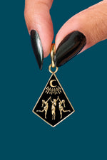 Hand holding Coven Charm of 3 women under a crescent moon