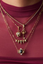 Gold necklaces against red mesh shirt