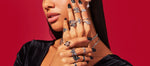 Woman wearing silver rings on red background